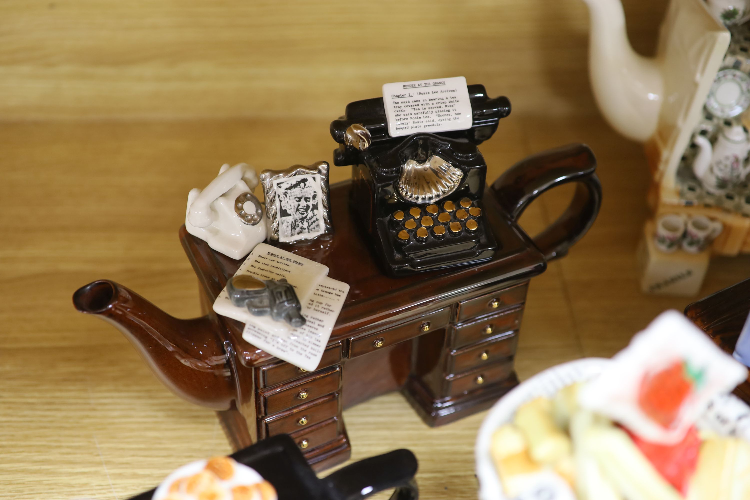 A collection of thirteen Portmeirion and Cardew novelty teapots, including dresser, sewing machine and kitchen range examples